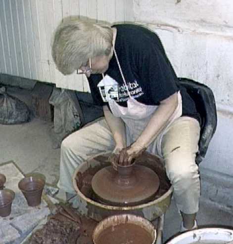 photo of Debra Ocepek throwing a clay pot on the potters wheel