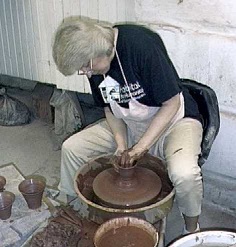 photo of Debra Ocepek throwing a pot on the potter's wheel