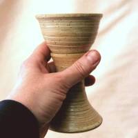 photo of hand holding the travel goblet in cream glaze by Ocepek Pottery